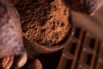 Chocolate bar, candy sweet, cacao beans and powder on wooden background