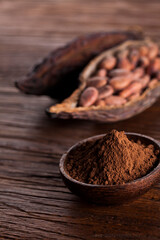 Cocoa beans in the dry cocoa pod fruit on wooden background