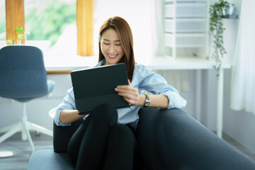 internet learning, online shopping, selling, meeting, information searching, young Asian woman  using tablet mobile to work at home.