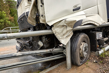 Car accident: truck after collision with road barrier