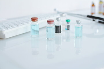 Vaccine bottle and syringe placed on a white table. Healthcare and medical concept.