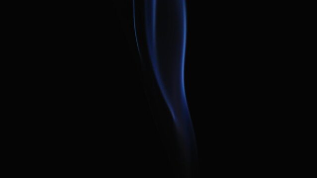 Abstract blue color smoke with a black background in slow motion. Realistic cloud smoke with a streamlined pattern.