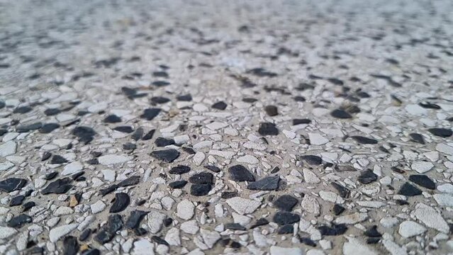 Close-up macro shot of seamless terrazzo pattern of marble mosaic natural concrete floor. Slow-motion.