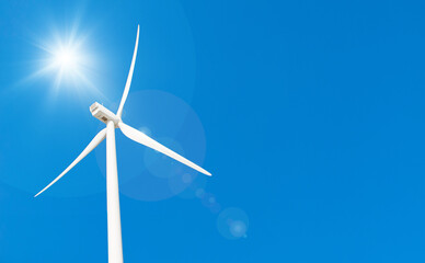 wind turbine in the wind with blue sky in background under sun light