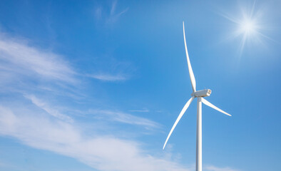 wind turbine in the wind with blue sky in background under sun light