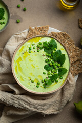 Assiette soupe froide gaspacho de petit pois menthe et yaourt avec crackers aux graines