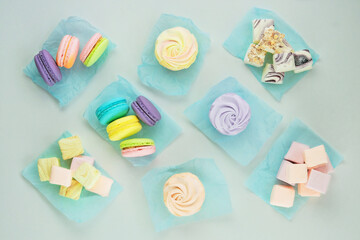 Assortment of desserts: macaroons, marshmallows and zephyrs, closeup. Traditional colored sweet desserts for the holiday. Top view.
