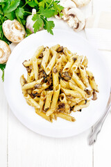Pasta with mushrooms in white plate on light board top