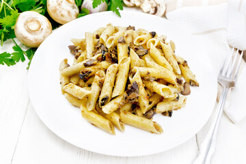 Pasta with mushrooms in white plate on wooden board