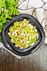 Salad of beans and olives in plate on dark board top