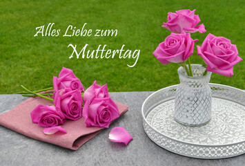 Grußkarte zum Muttertag. Rosen auf einem Tisch im Garten mit dem Text  Alles Liebe zum Muttertag.