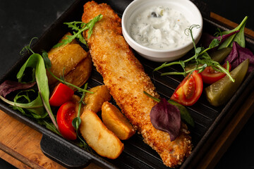 One piece of baked salmon grilled lemon and salt on a dark plate with potatoes. marble background
