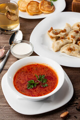 Traditional ukrainian dish vareniki and borscht served with greaves and sour cream. Close up view of traditional Ukrainian food.