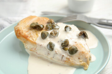 Delicious cooked chicken fillet with capers and sauce served on white table, closeup