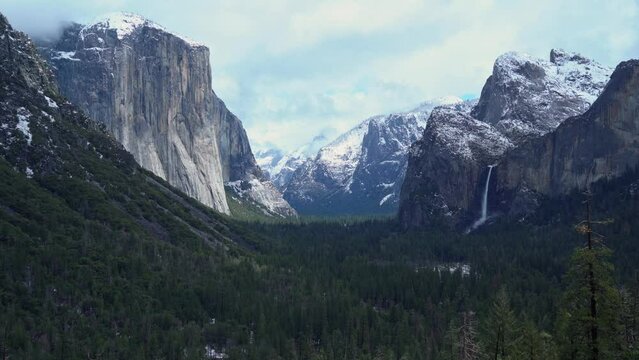 Wide shot of Yosemite Valley with light snow covering the mountains.