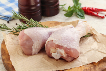 Raw chicken leg over board