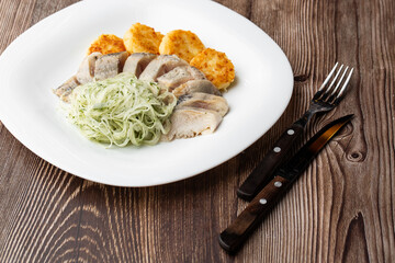 Herring with potatoes and onions on a plate. Ukrainian traditional cuisine on wooden background.