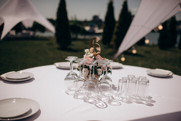 banquet table setting under a white tent on the grass