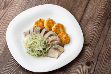 Herring with potatoes and onions on a plate. Ukrainian traditional cuisine on wooden background.