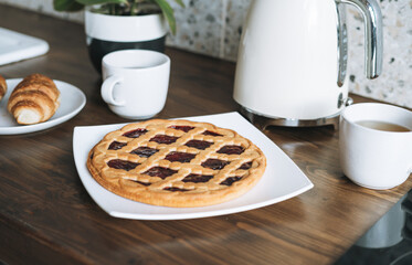 Work surface table with pastries and kettle in kitchen at home