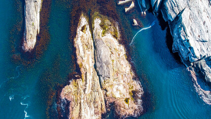 Aerial view of the sea wave and rocks of the coastline of Norway, Telavåg. Panoramic view of the rocks by the sea. The sea wave rolls along the shore. View of the sea coast from the air. Ocean space