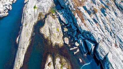 Aerial view of the sea wave and rocks of the coastline of Norway, Telavåg. Panoramic view of the rocks by the sea. The sea wave rolls along the shore. View of the sea coast from the air. Ocean space