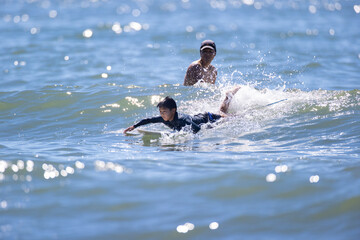 湘南の海でサーフィンをする親子