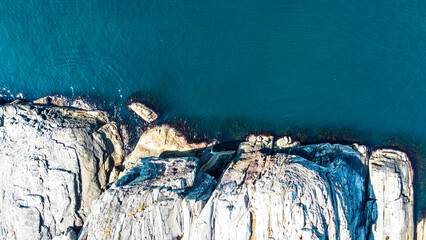Aerial view of the sea wave and rocks of the coastline of Norway, Telavåg. Panoramic view of the rocks by the sea. The sea wave rolls along the shore. View of the sea coast from the air. Ocean space