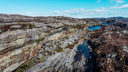 Aerial view of the sea wave and rocks of the coastline of Norway, Telavåg. Panoramic view of the rocks by the sea. The sea wave rolls along the shore. View of the sea coast from the air. Ocean space