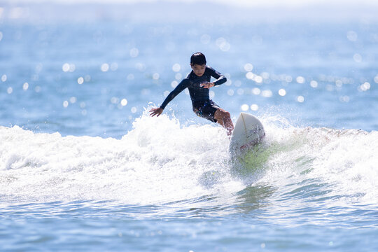 湘南の海でサーフィンをする少年