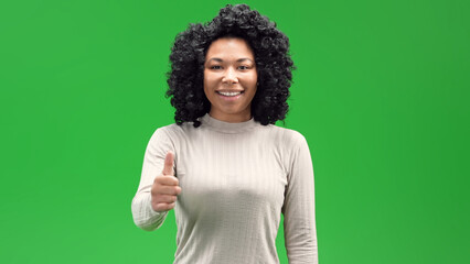 An African American young woman with thumbs up hand gesture on a green chroma background