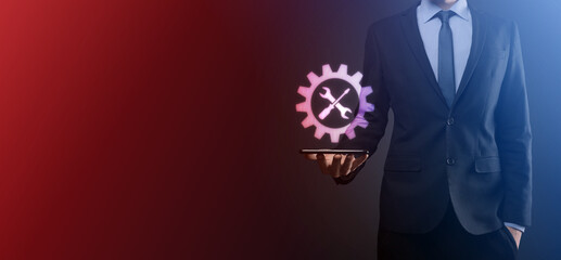 Businessman holding gear icon with tools.Gearing.Concept of target focus digital diagram,graph interfaces,virtual UI screen,connections netwoork.