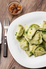 Traditional ukrainian dish vareniki served in a bowl with greaves and basil sauce. Close up view of traditional Ukrainian food.