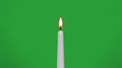 white candle burns on green screen