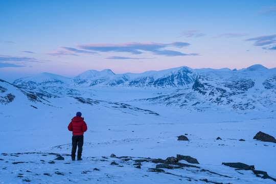 A man enjoying the view over the snow covered mountains in Swedish Lapland.