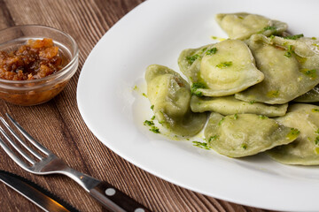 Traditional ukrainian dish vareniki served in a bowl with greaves and basil sauce. Close up view of traditional Ukrainian food.