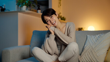 パジャマを着てソファーに座る若い女性