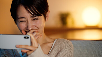 スマートフォンで動画を視聴する若い女性