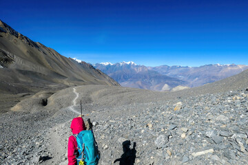 A woman hiking through dry path in Himalayan valley, located in Mustang region, Annapurna Circuit...