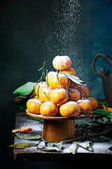 Beautiful shot of mandarins laid in a pyramid shape with a sifted powdered sugar