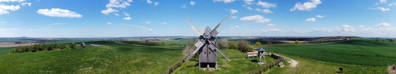 Fototapeta na wymiar A drone flight of a historic wooden windmill in a panoramic view