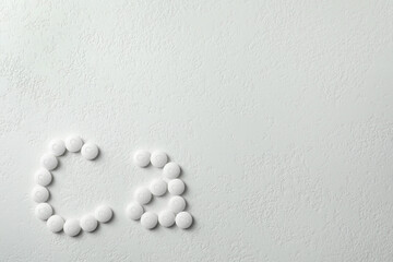 Flat lay composition with calcium supplement pills on white background, space for text