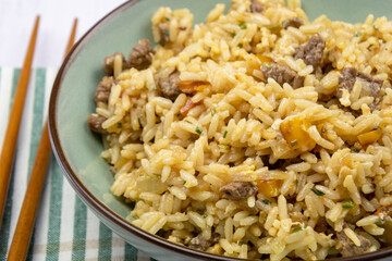 close up of a beef fried rice in a plate on a table