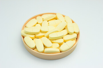 A pile of calcium and vitamin D supplement tablets. Isolated	