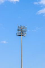 Huge pole of stadium light projectors against a sky