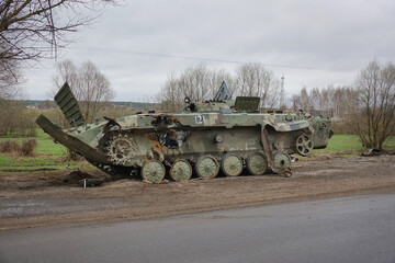 Military armored vehicles on the road. Army armored car blown up. War in Ukraine.