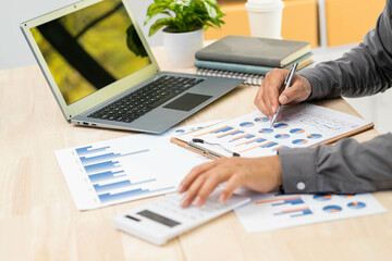 Businesswoman pointing pen on business document at meeting room.Discussion and analysis data charts and graphs showing the results at meeting.