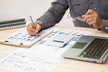 close up of businessman hand working on laptop computer with business graph information diagram on...