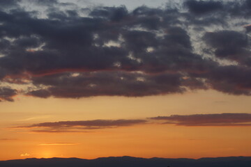 Fototapeta na wymiar Sonnenuntergang mit Bäumen im vordergrund und ein farbenspiel der wolken