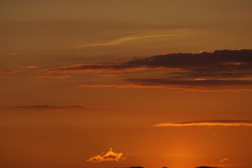 Sonnenuntergang mit Bäumen im vordergrund und ein farbenspiel der wolken